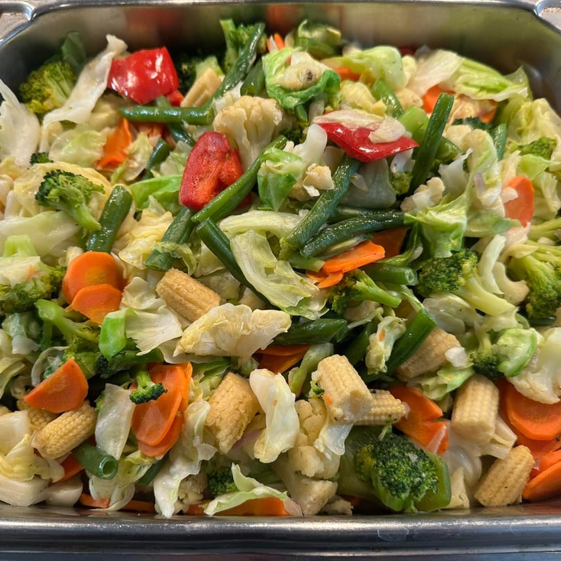 A vibrant mix of stir-fried vegetables, including broccoli, carrots, cabbage, and red peppers.